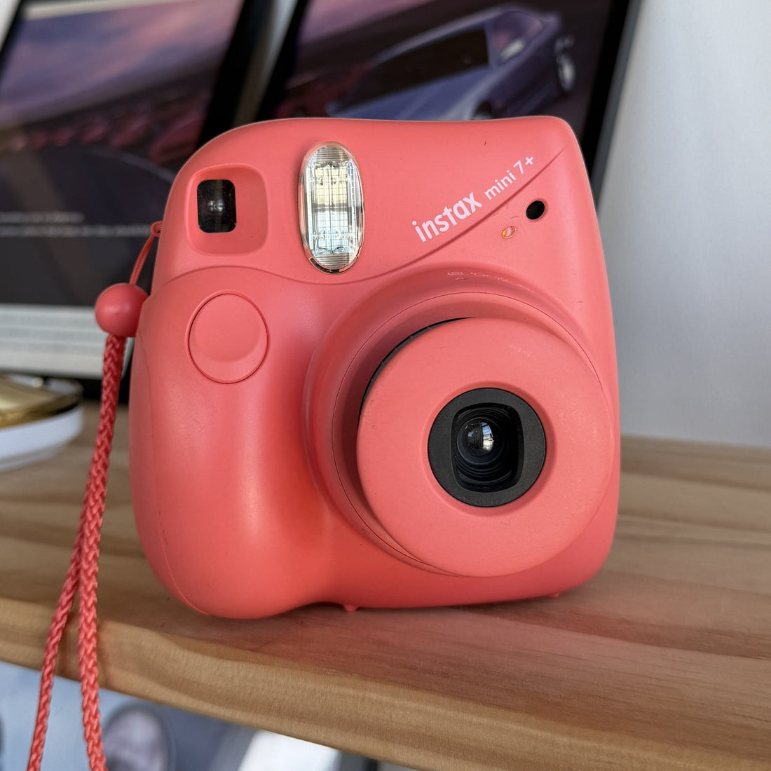 Fujifilm Instax Mini 7+ instant camera in coral, front